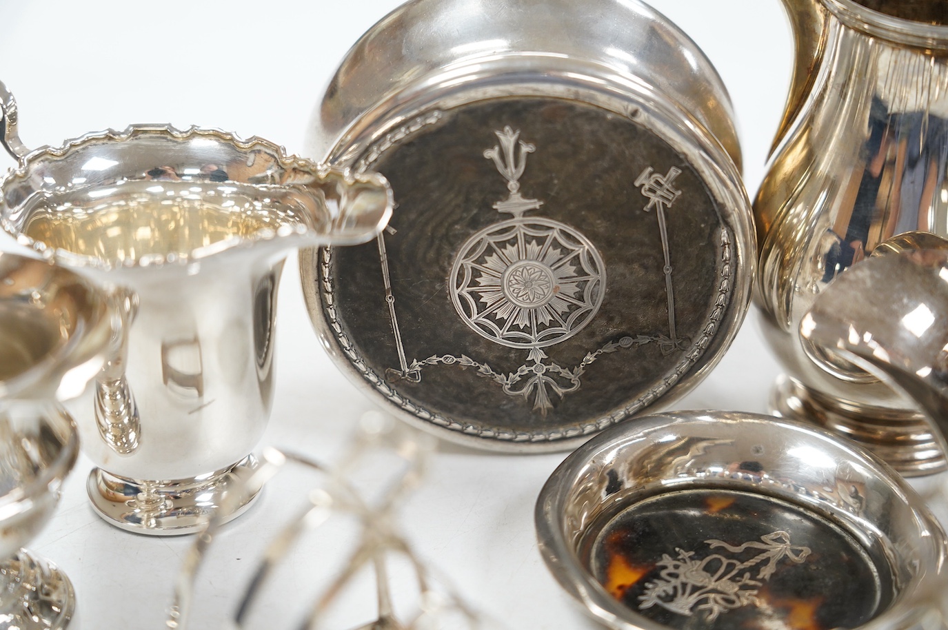 Sundry small silver including a pair of toast racks, Sheffield, 1936, three cream jugs, a sauceboat and two tortoiseshell mounted items. Condition - poor to fair to good